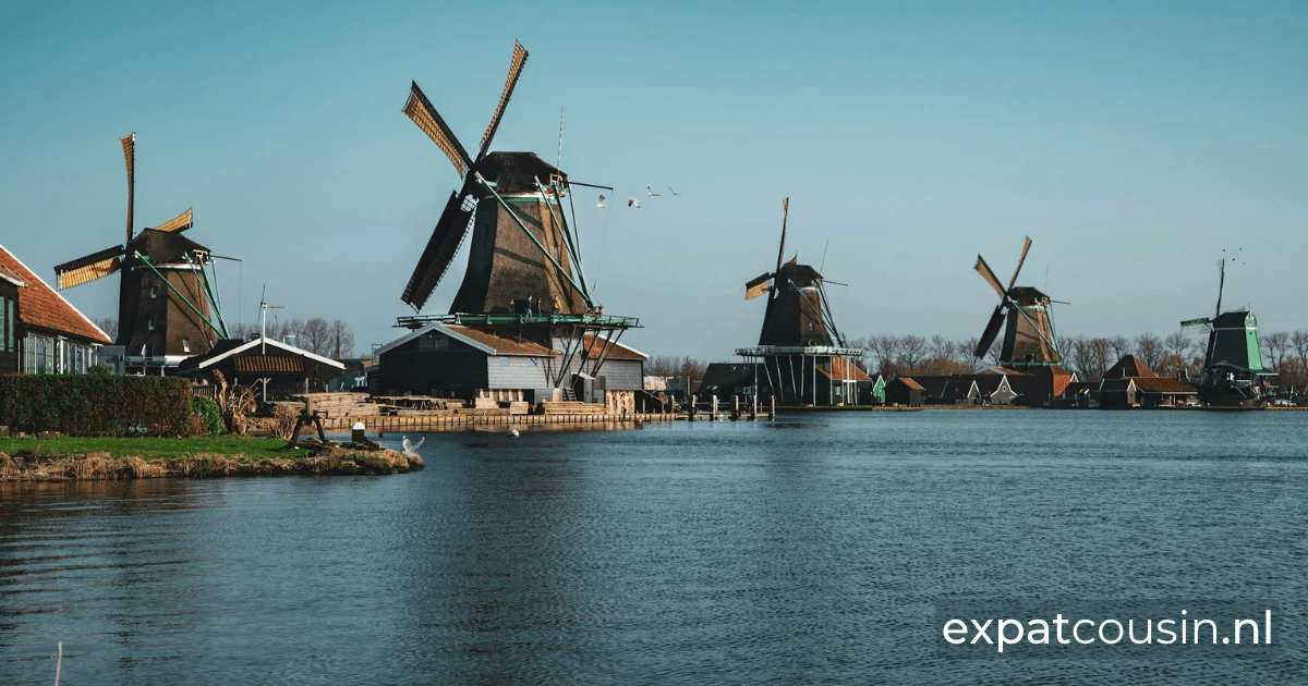 A row of dutch historic windmills along a body of water